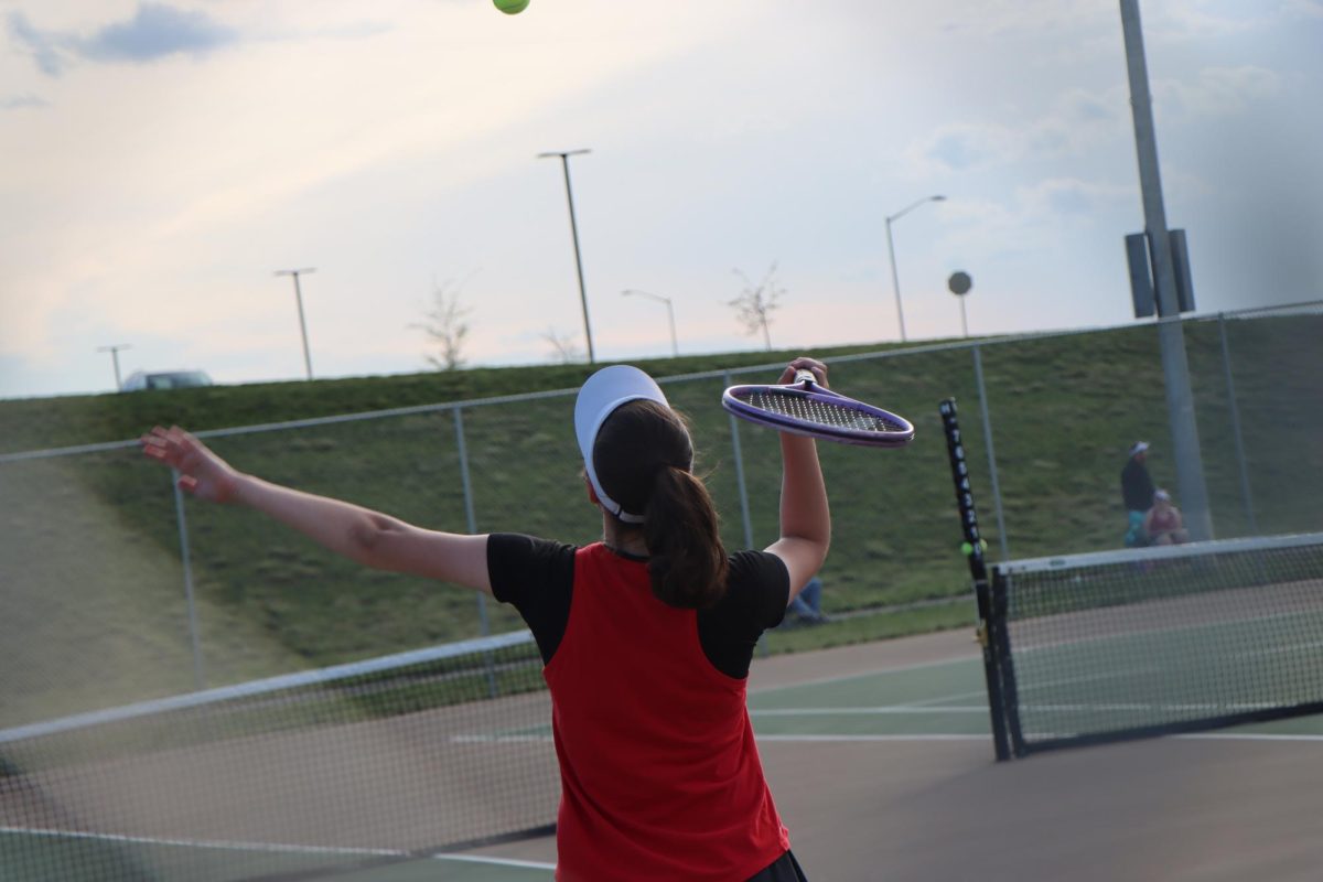 Taylor Moore is prepared and ready to serve the ball over the net.
