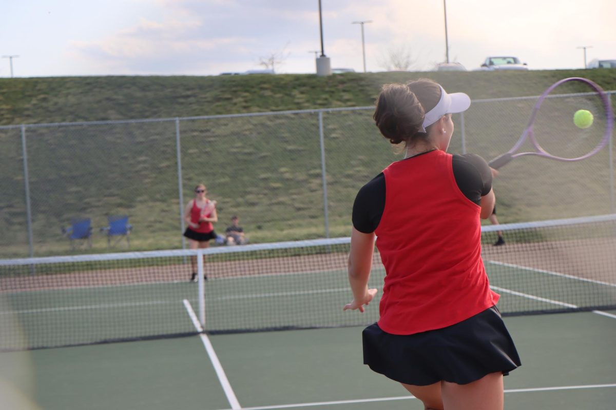 Taking a big swing, Taylor Moore hits a good shot to her opponent.
