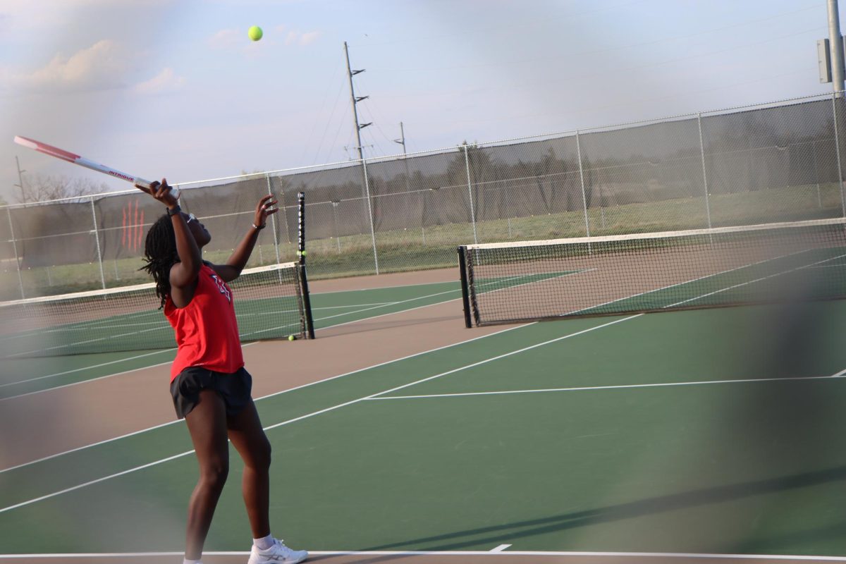 Olamitesiwaju Akinyemi tosses the ball high for a serve.
