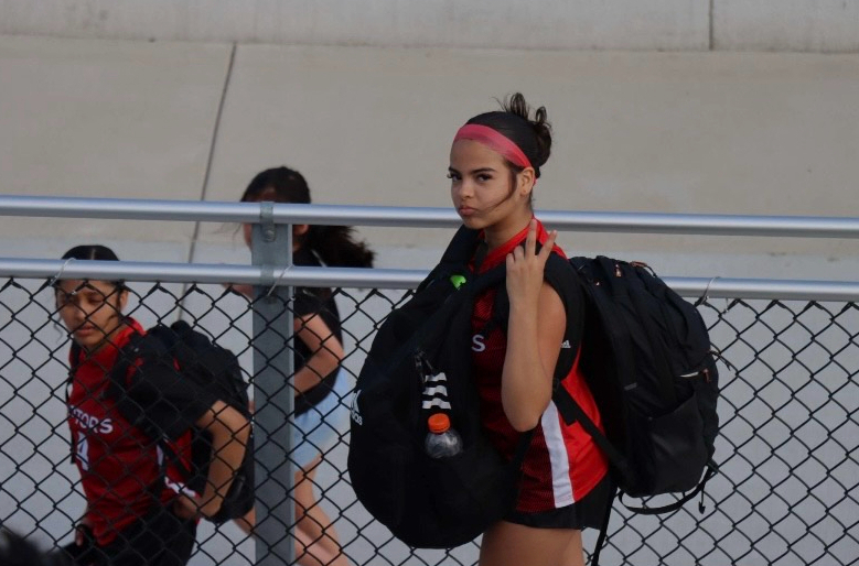 Freshman Emily Barahona makes the "V sign" while she walks to go warm up before the game against Broadway High School.