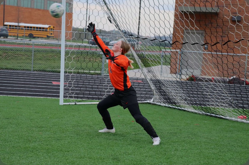 Senior Kiele Neil saves a goal at warm ups before the game against Broadway High School.