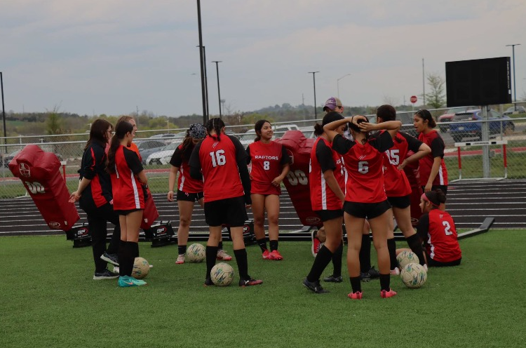 Coach LaBarbera gives a talk  to the varsity soccer girls while they prepare for the game against Broadway.